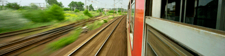 View of train tracks from window of speeding train