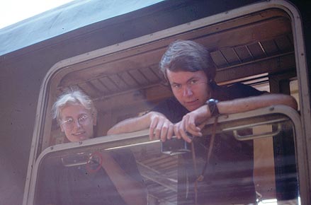 Backpackers looking out an open train window